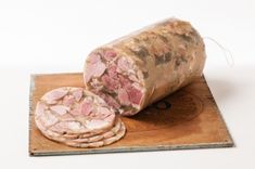 a piece of meat sitting on top of a cutting board next to some crackers