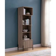 a tall bookcase with three shelves in front of a blue wall