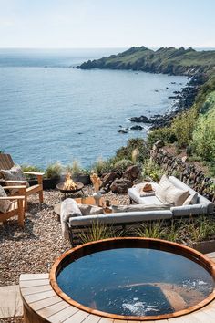 a hot tub sitting on top of a wooden deck next to the ocean