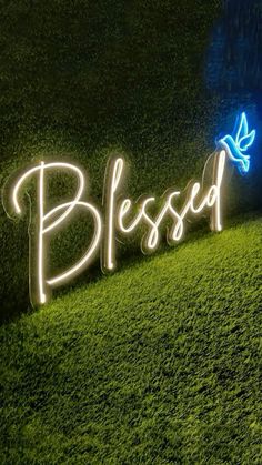 a sign that says,'blessed'in neon lights on the side of a grass field