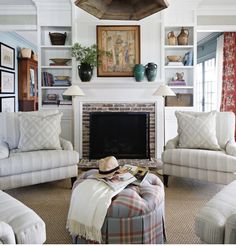 a living room filled with furniture and a fire place in front of a painting on the wall