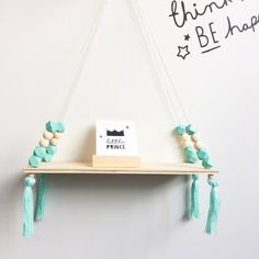 a shelf that has some beads on it and a sign hanging from the top with tassels