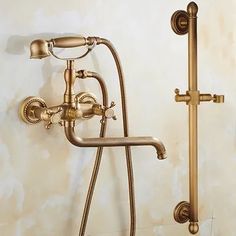 an antique brass shower faucet with hand shower head and handset