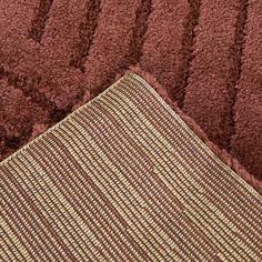 a close up view of a brown and gold rug on a bed with two pillows