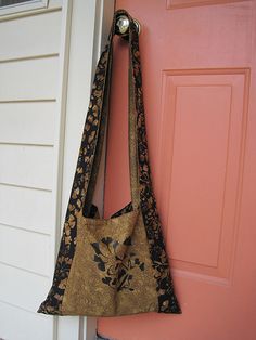 a handbag hanging on the side of a door with a pink wall behind it