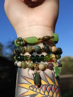 This is a handmade, natural crystal bracelet stack. Each bracelet is approximately 7 inches in length around and made with stretch wire. This version features natural green jasper, serpentine and Czech crystal with gold plating. It has two pendants: a green butterfly and a green aventurine cabochon. This is a 4 piece set! This is a handmade item and may be subject to some slight flaws. No two items will be the same. Green Agate Stretch Bracelet With Natural Stones, Hand-strung Green Agate Stretch Bracelet, Green Agate Crystal Bracelet With Gemstone Beads, Green Agate Hand-strung Crystal Bracelet, Green Jade Stretch Bracelet For Meditation, Bohemian Green Agate Crystal Bracelet, Green Aventurine Stretch Bracelet With Natural Stones, Green Aventurine Crystal Bracelet With Natural Stones, Handmade Green Aventurine Crystal Bracelet