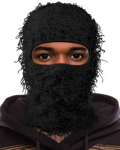 a man wearing a black mask and hood with hair on his face, looking at the camera