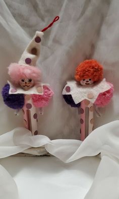 two small wooden pegs with clown faces on them