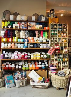 there are many yarns on the shelves in this shop and it is very colorful