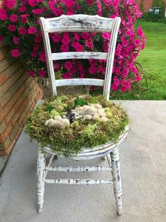 a white chair with moss and flowers on it