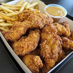 fried chicken and french fries in a box with dipping sauce