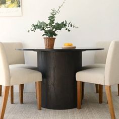 a table with four chairs around it and a potted plant in the center on top