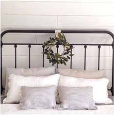 a bed with two pillows and a wreath on the headboard