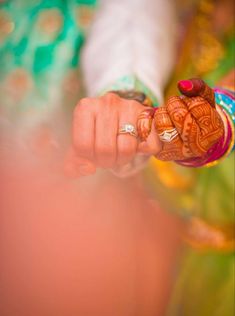 a close up of a person holding something in their hand and wearing jewelry on her wrist