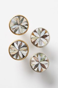 three pairs of gold and white diamond studs on top of each other in front of a white background