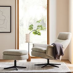 a living room with a chair, ottoman and rug on the floor in front of a window