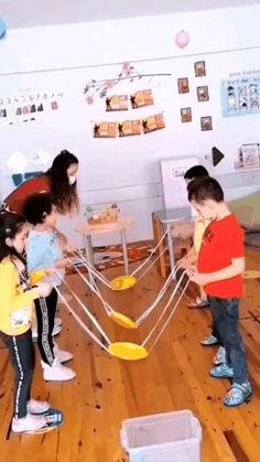 several children are playing with yellow frisbees in a room