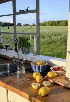 a kitchen counter with lemons, strawberries and other fruits on it in front of a window