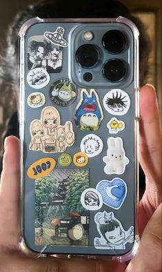 someone is holding up their phone case with many stickers on it in front of the camera