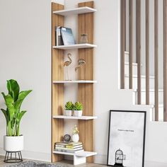 a living room with a plant and bookshelf on the floor next to stairs