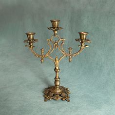 an ornate gold candelabra with four candles on each candle holder, set against a blue background