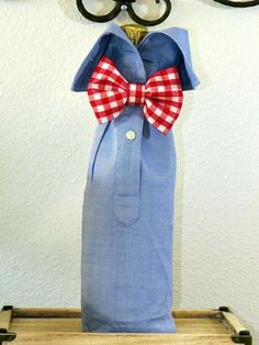 a blue bag with a red and white bow tie hanging from it's side