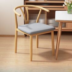 a wooden chair sitting in front of a desk with a vase on top of it