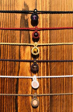 five different colored bracelets on top of a wooden table