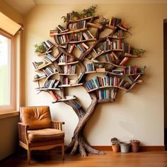 a tree shaped bookshelf in the corner of a room next to a chair