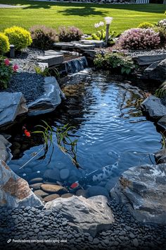 a small pond surrounded by rocks and flowers