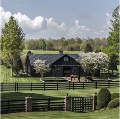 two horses are standing in front of a black barn with white trim on the windows