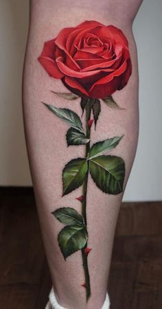 a woman's leg with a rose tattoo on the side of her thigh,