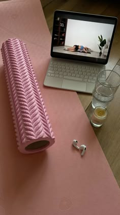 a pink object sitting on top of a table next to a laptop computer and two glasses