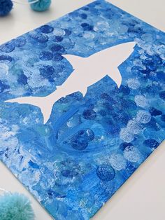 a blue painting with a white shark on it