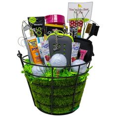 a basket filled with golf balls and other items on top of a green grass covered field