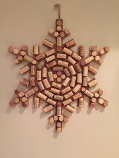 a snowflake made out of wine corks hanging on the side of a wall