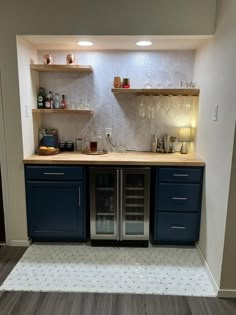 a kitchen with blue cabinets and white tile flooring is shown in this image, there are shelves on either side of the counter