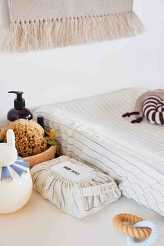 the baby items are neatly arranged on the table in front of the crib and wall hangings