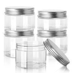 four clear jars with lids are stacked on top of each other and one is empty