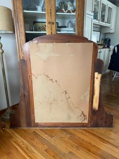 an old wooden cabinet sitting on top of a hard wood floor next to a lamp