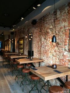 tables and stools are lined up against a brick wall