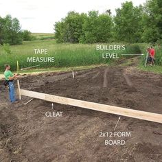 a man standing in the middle of a dirt field next to a wooden fence and some trees