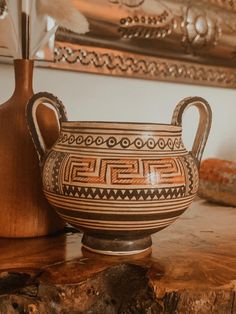 a vase sitting on top of a wooden table next to a mirror and other items