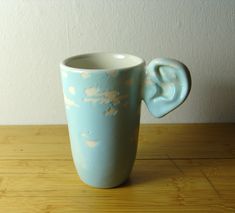 an elephant shaped vase sitting on top of a wooden table next to a white wall