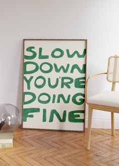 a chair sitting next to a poster with the words slow down you're doing fine