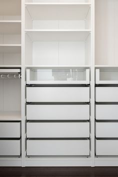 an empty white closet with drawers and shelves