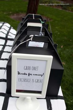 a table topped with black and white boxes on top of a checkered table cloth