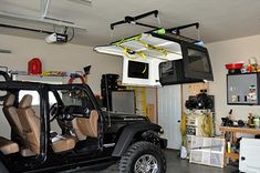 a jeep is parked in a garage with its doors open and it's lights on