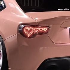 a pink car with the word love written on it's tail lights and bumper stickers