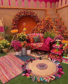 a living room filled with lots of colorful furniture and flowers on the floor next to stairs